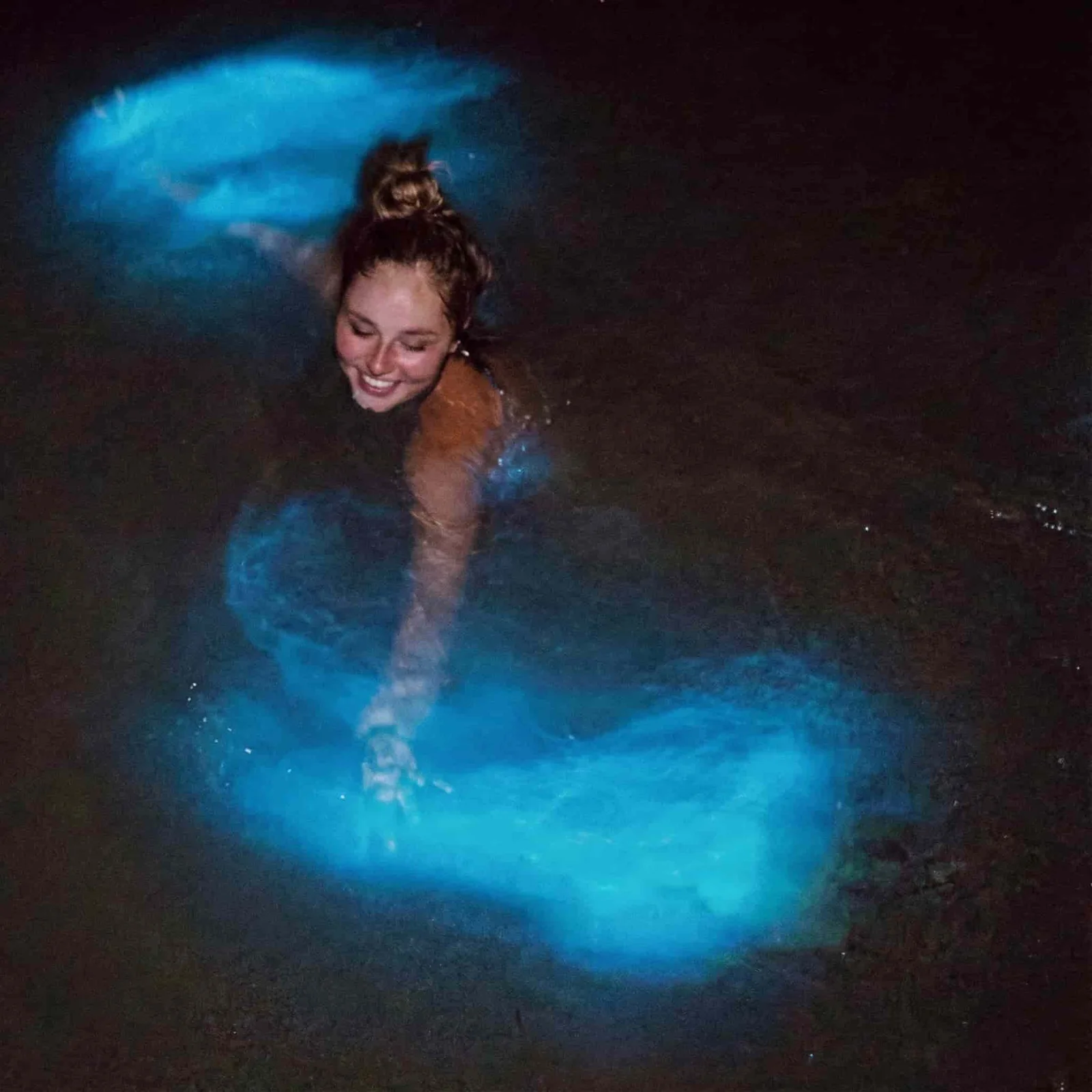 Nadadores rodeados de bioluminiscencia azul neón en la Laguna de Manialtepec, Oaxaca